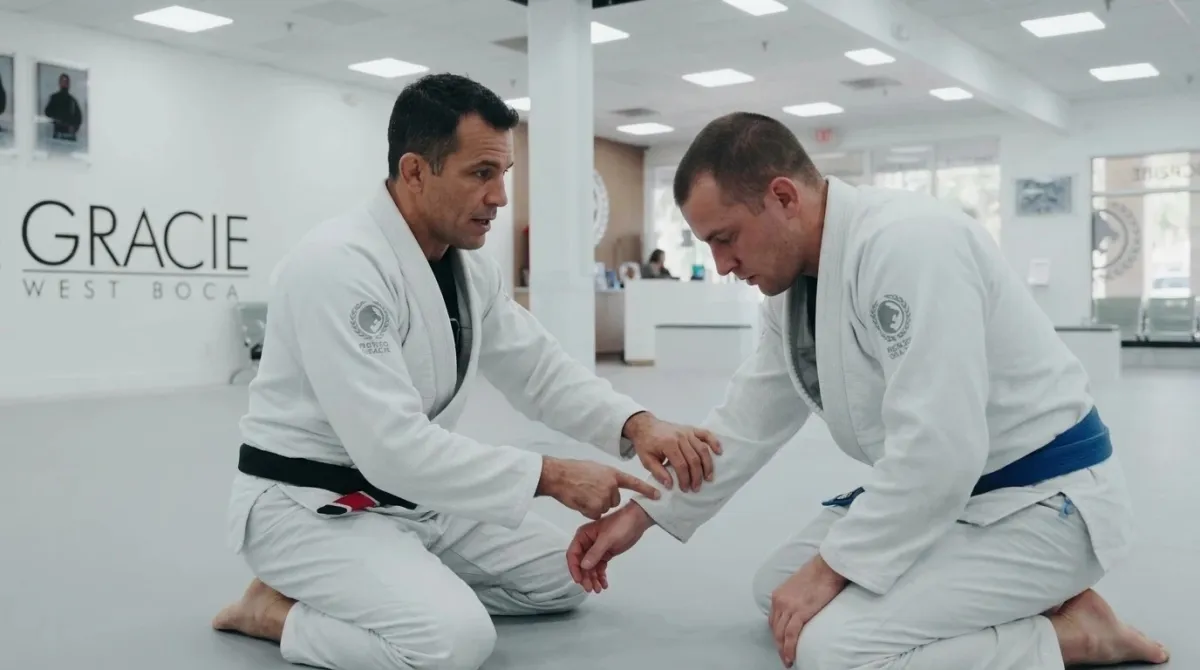 An instructor demonstrating a hip movement to one adult student on the mat