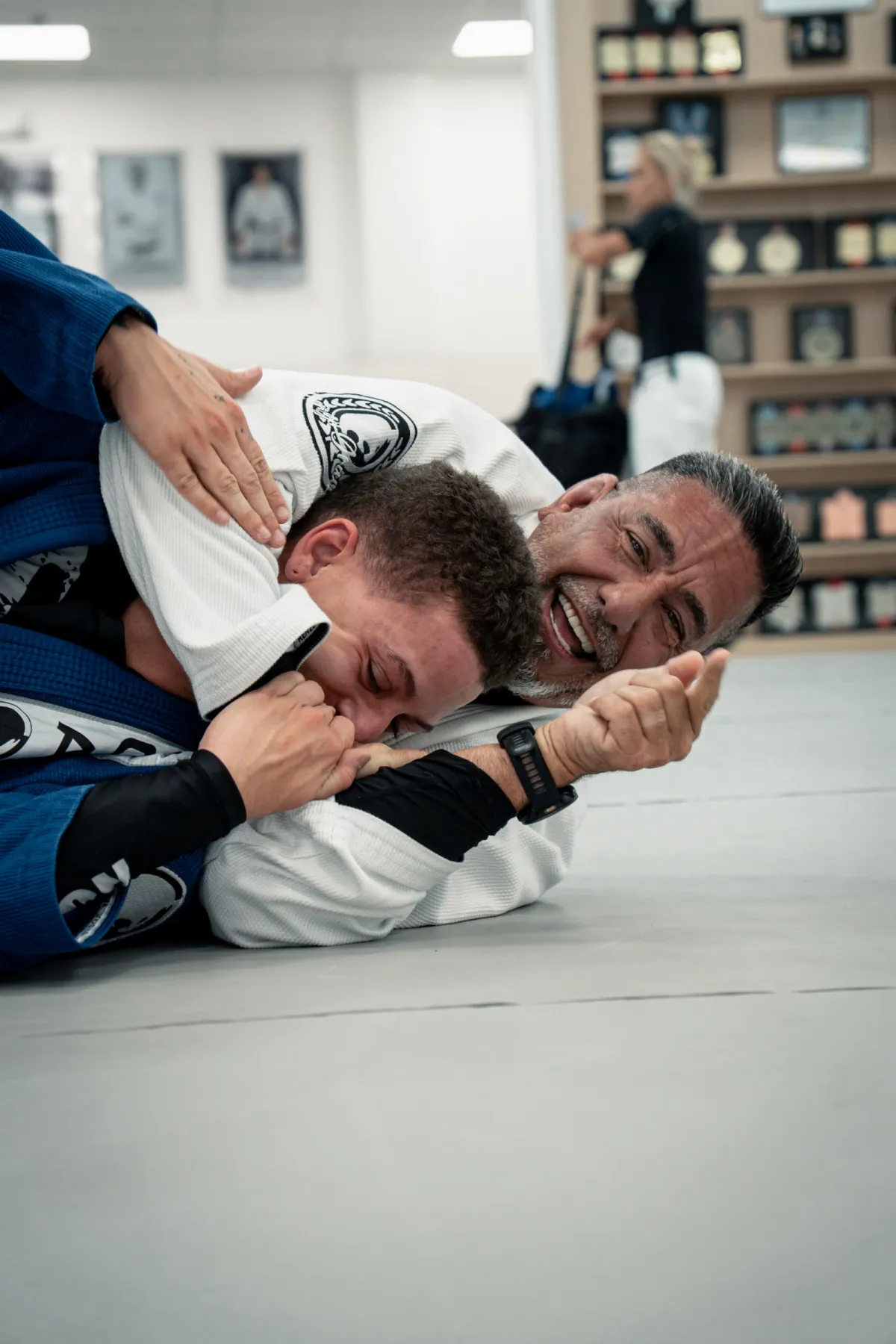 Instructor enseñando y riendo con los alumnos en el tatami en Renzo Gracie West Boca Raton