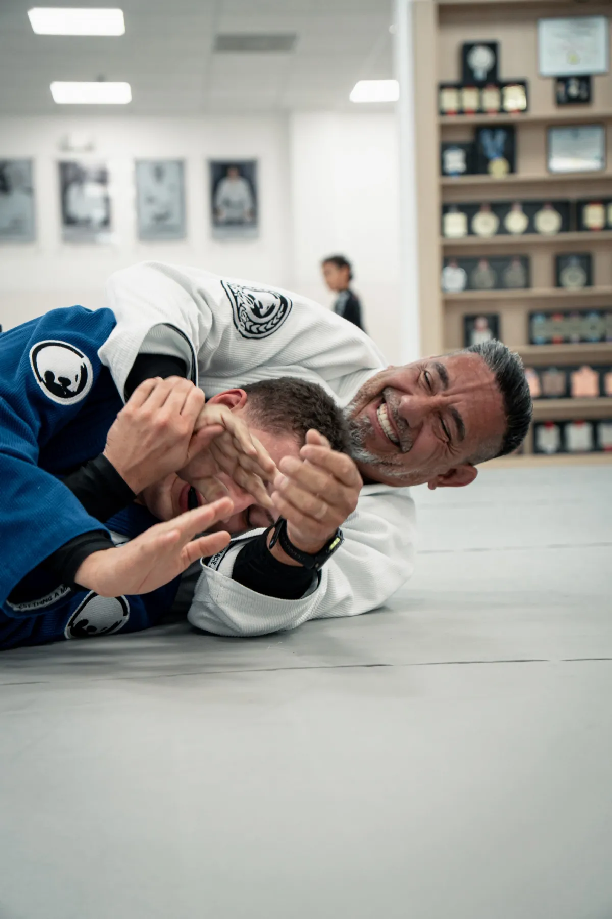 Instructor teaching and laughing with students on the mat at Renzo Gracie West Boca Raton