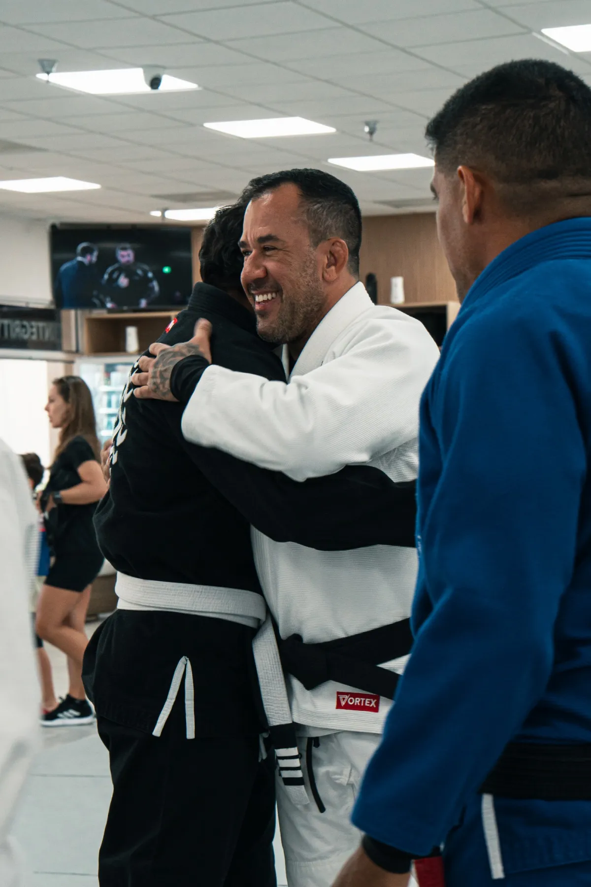 Instructor teaching and laughing with students on the mat at Renzo Gracie West Boca Raton