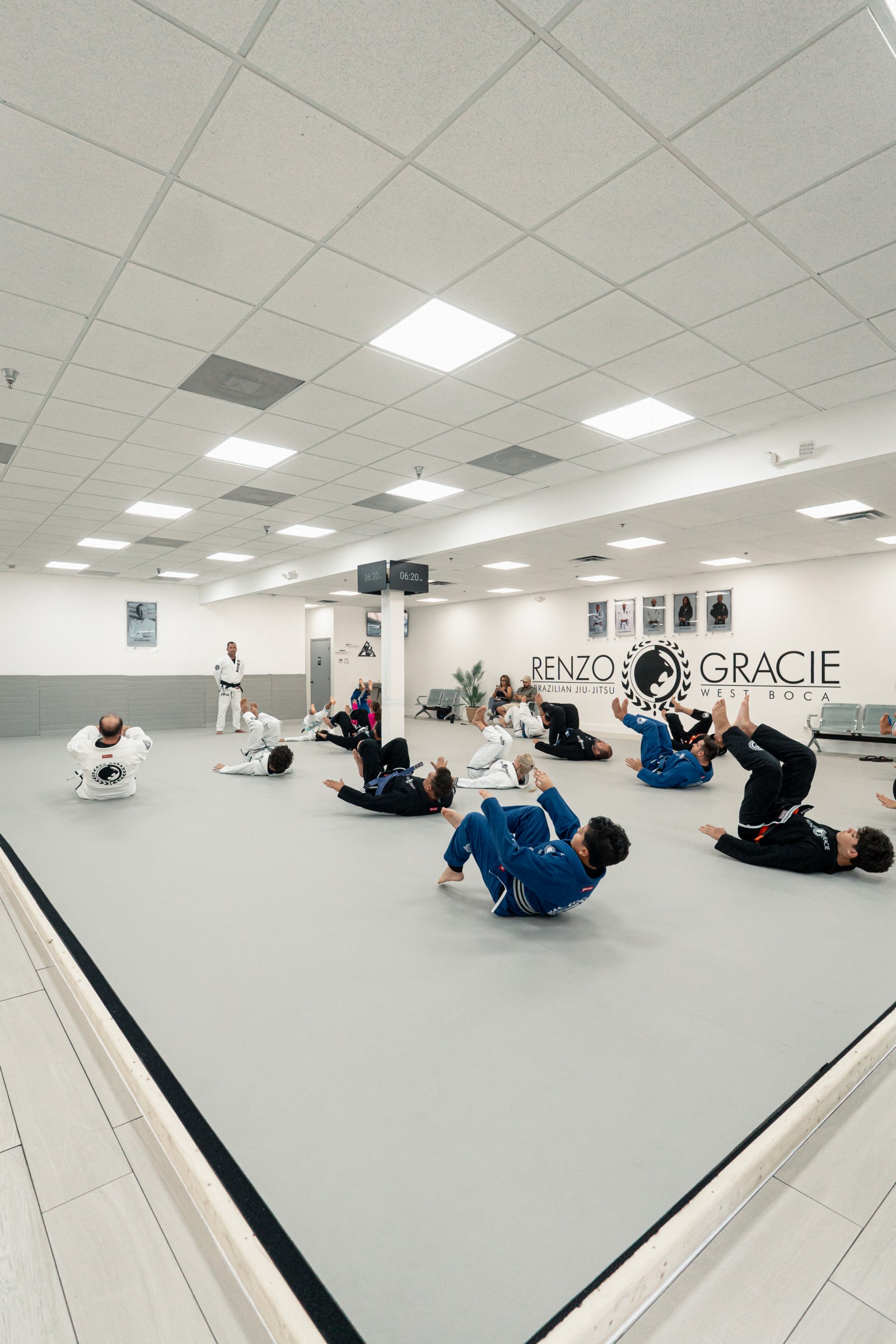Wide view of the bright training room with students practicing on the mat