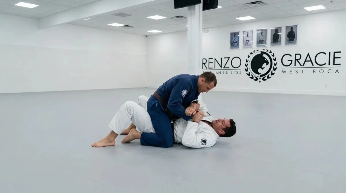Two men in the wide open mat area of Renzo Gracie West Boca drilling an americana from mount.
