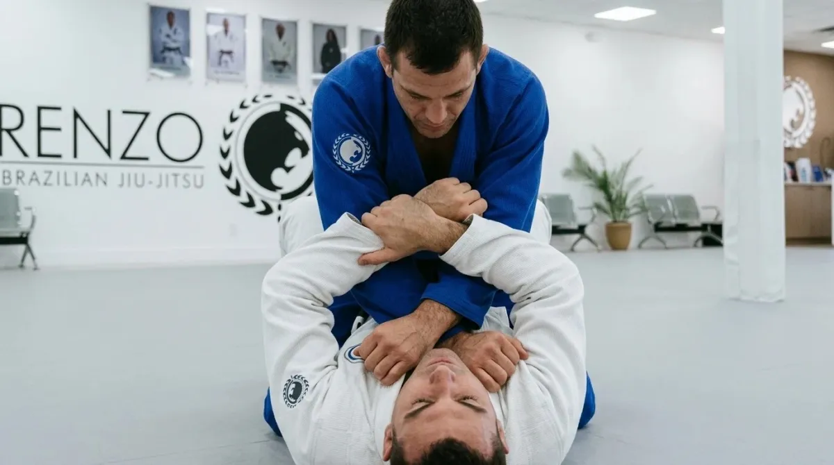 Two men on the mat at Renzo Gracie West Boca: the top man sets a cross collar choke from mount.